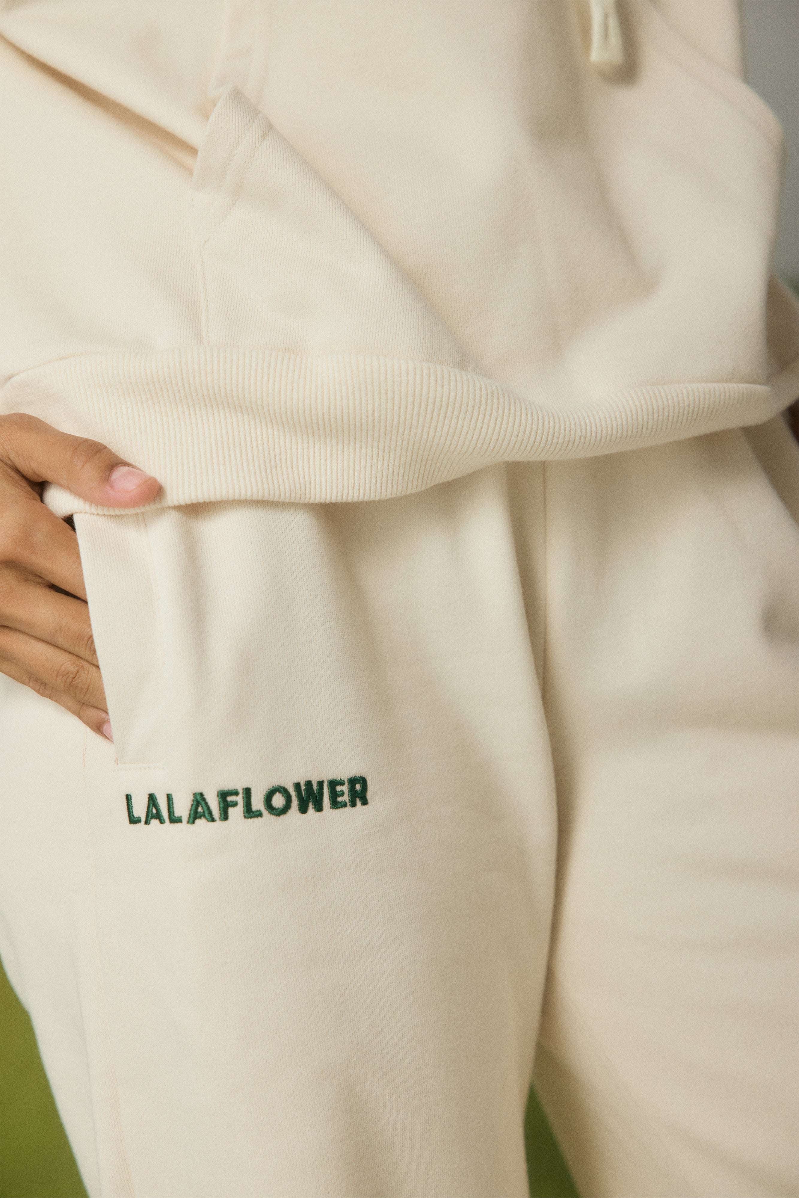 OFF-WHITE SWEATPANTS WITH GREEN EMBROIDERY